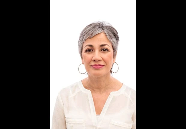 A middle aged woman smiling confidently, reflecting natural vitality and optimized feminine health balance